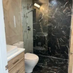 Dark marble shower and vanity in luxury bathroom