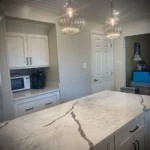 Close-up of white waterfall island with veined marble countertop