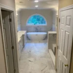 Bathroom with arched window and freestanding tub