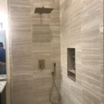 Gray tile shower with built in niche
