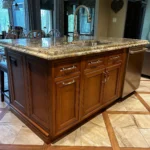 Wood cabinetry kitchen with granite island and pendant lighting