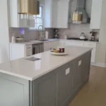 Gray two-tone kitchen with marble island and pendant lighting
