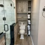 Glass shower with wood look tile and dark cabinet