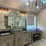 Bathroom with mirrored vanity and chandelier lighting