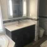 Dark vanity with marble backsplash