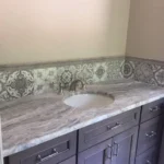 Dark vanity with patterned marble backsplash detail