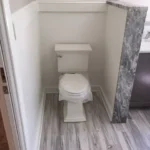 Toilet area with marble accent wall