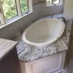 Oval tub with marble vanity near window