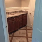 Bathroom vanity with granite countertop and dark cabinets
