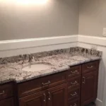 Gray vanity with granite countertop