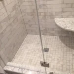 Corner shower with tile flooring and niche