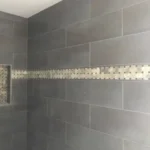 Tile shower wall with mosaic accent strip