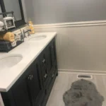 Dark wood vanity with white countertop and bath mat
