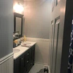 Dark wood double vanity bathroom with wainscoting