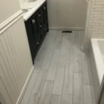 Bathroom with wood look tile flooring and wainscoting