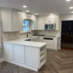 White U-shaped kitchen with wood accent range hood and island