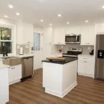 White kitchen with dark countertop island and stainless appliances