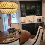 Kitchen with dark cabinetry, built-in wine storage and gold pendant lighting
