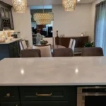 Kitchen with marble island, dark cabinetry and adjoining dining area