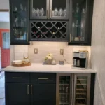 Dark green kitchen with built-in wine rack and marble counters