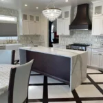 Kitchen with dark waterfall island, upholstered bar stools and patterned floor tile