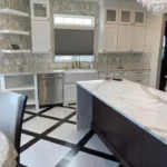 Kitchen with dark waterfall island and patterned black and white floor tile