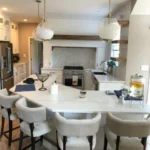 White kitchen with round dining table and upholstered chairs