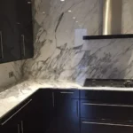 Dark kitchen with marble slab backsplash
