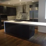 White waterfall island with marble countertop and pendant lighting