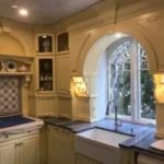 Cream kitchen with arched cabinet niche and decorative tile