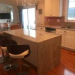 Kitchen with gray marble waterfall island and bar stool seating