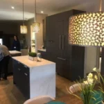 Kitchen with white waterfall island and dining pendant lighting