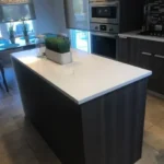 Dark kitchen with white marble-top island