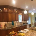 Wood cabinetry kitchen with granite island and pendant lighting