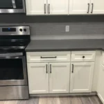 White kitchen with stainless range and dark countertops