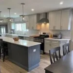 White kitchen with dark island and pendant lighting